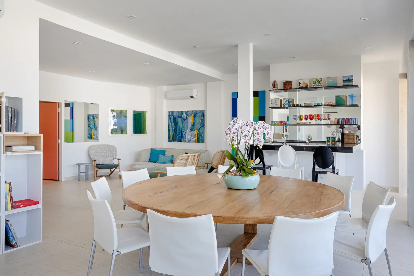 Dining table beside the glass, terrace and beach beyond