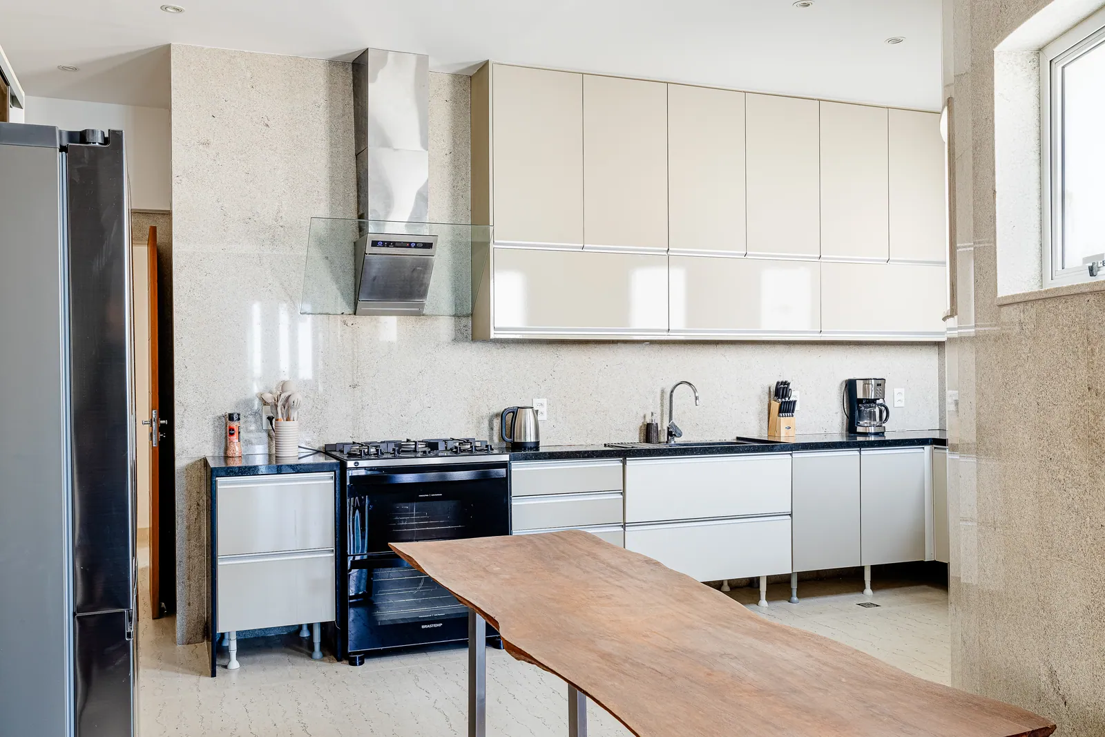 Second kitchen with large refrigerator and solid wood table