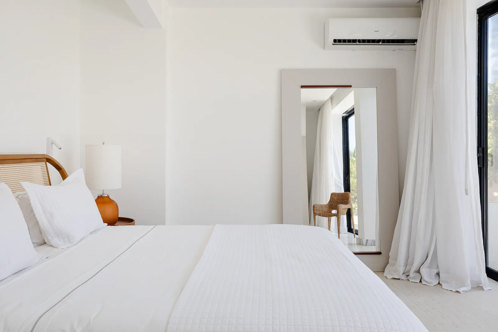 Bedroom with open wardrobe, safe and marble bathroom beyond