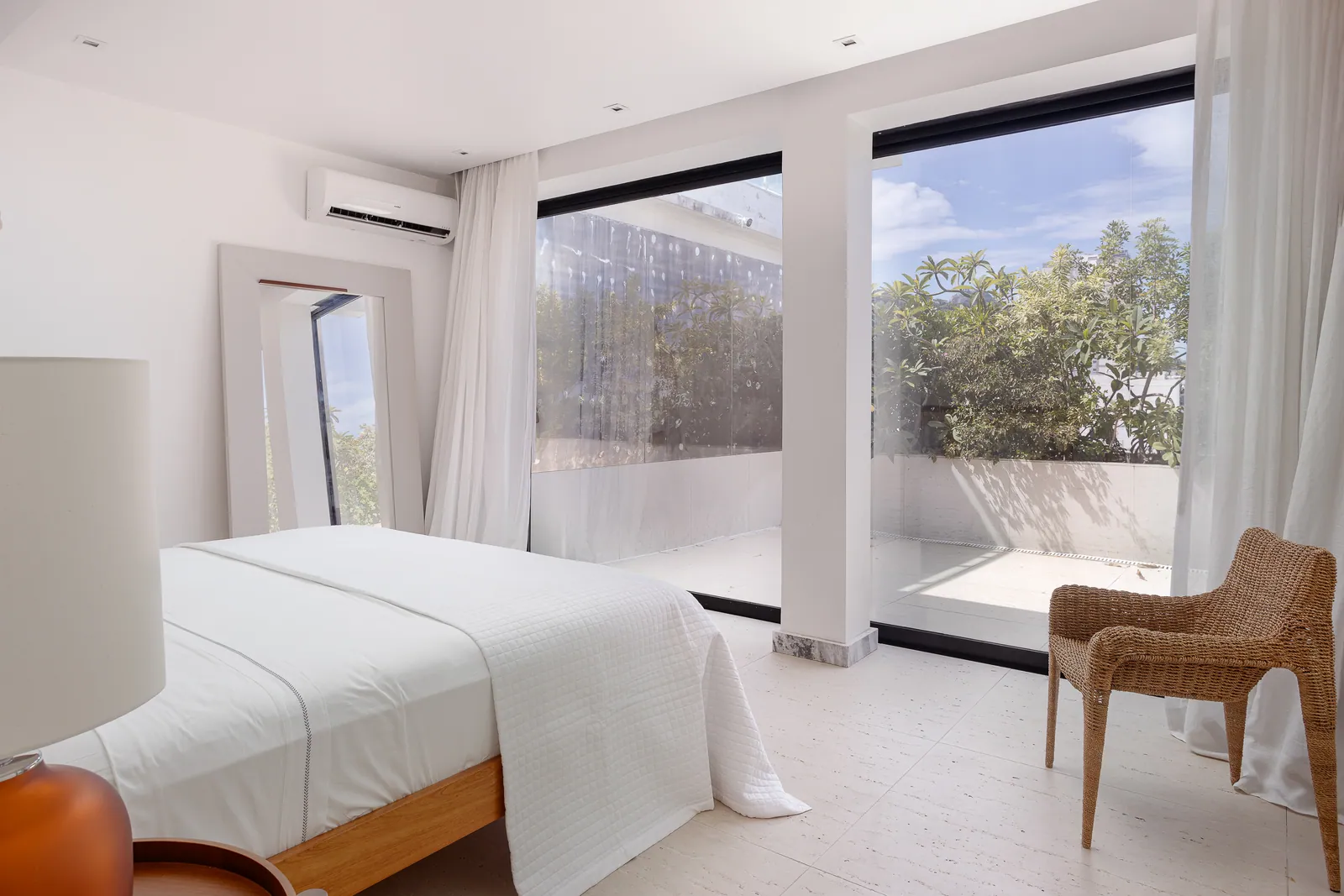 Bedroom with rattan armchair and wood headboard